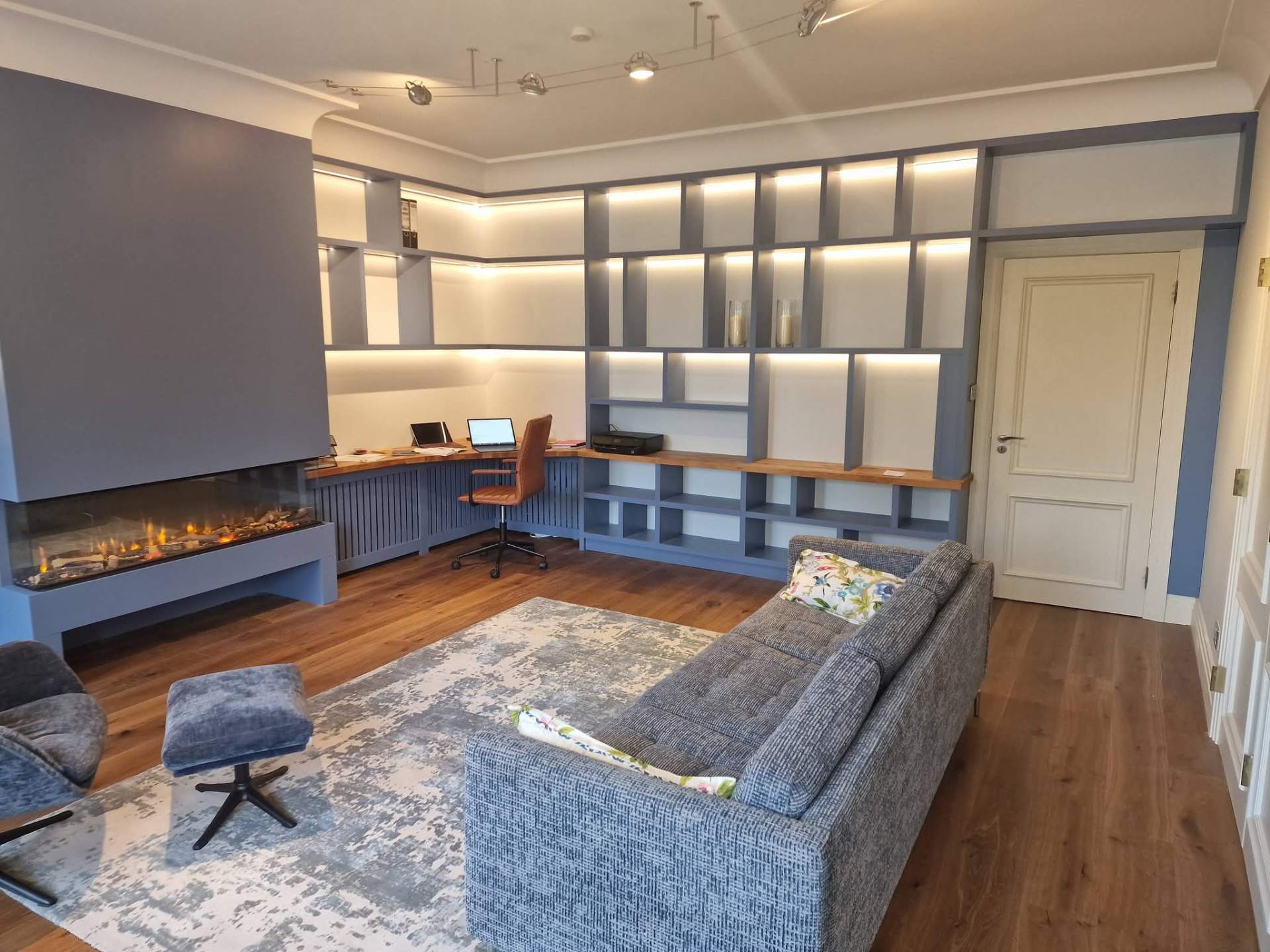 Library-style home office with integrated lighting.