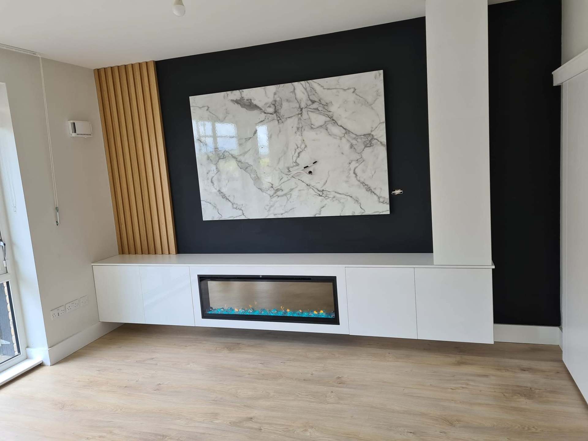 Floating media unit with integrated fire and marble panel.